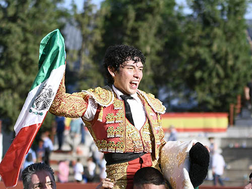 A hombros, con la bandera mexicana